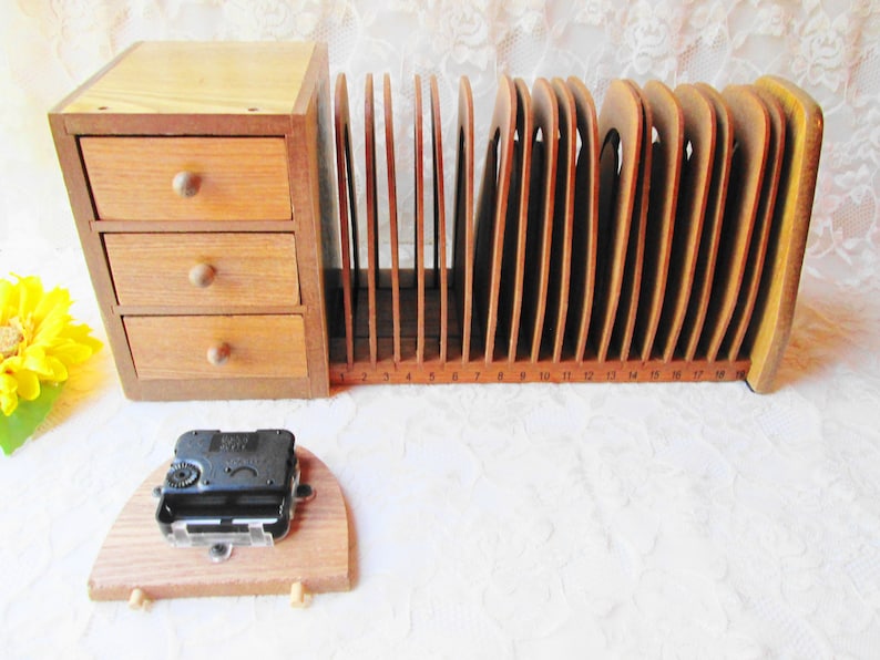 May include: Wooden organizer with three drawers and a letter holder with 18 slots numbered 1-18. The letter holder is made of wood and has a curved design. The organizer is a light brown color.