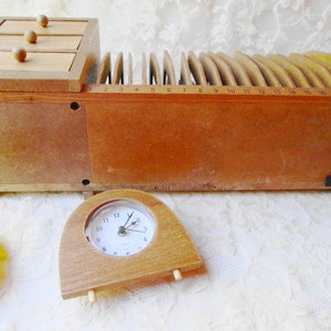 May include: A wooden desk organizer with three drawers and a letter sorter. The letter sorter has 17 slots numbered 1 through 17. A small wooden clock is in the foreground.