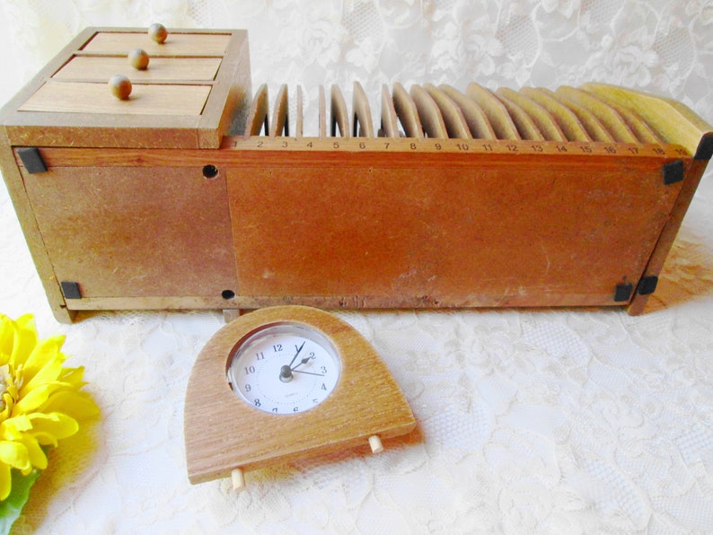 May include: A wooden desk organizer with three drawers and a letter sorter. The letter sorter has 17 slots numbered 1 through 17. A small wooden clock is in the foreground.