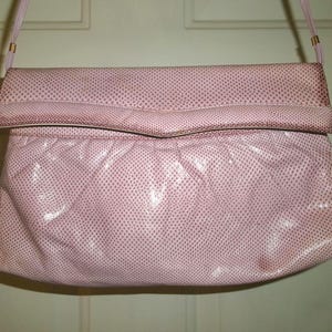 May include: A pink snakeskin-textured clutch purse with a flap closure and a thin shoulder strap.