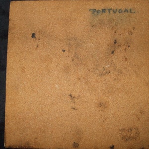 May include: A brown tile with the word "PORTUGAL" written in black ink.