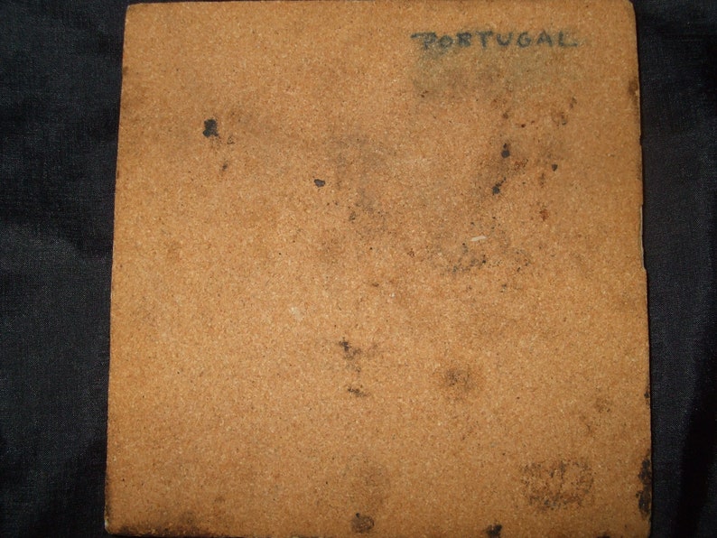May include: A brown tile with the word "PORTUGAL" written in black ink.