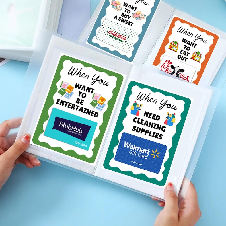 May include: A clear plastic photo album with several pages containing gift cards. The gift cards are for Krispy Kreme, StubHub, Chick-fil-A, and Walmart. Each card has a decorative border and text that reads "When You Want To..."