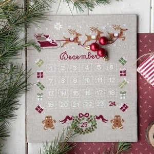 May include: A cross-stitch design of a December calendar featuring Santa Claus and reindeer pulling a sleigh. The calendar includes a wreath with the number 25 in the centre, and gingerbread men on either side. The design is surrounded by pine branches and red baubles.