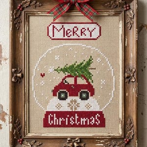 Op de afbeelding: Kruissteek kerstscène in een verweerde houten lijst. Het ontwerp toont een rode auto met een kerstboom in een sneeuwbol, met de woorden "MERRY" en "Christmas". Een geruite strik siert de bovenkant.