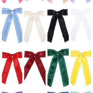 May include: A set of 12 hair bows in various colors, including pink, light blue, white, black, red, green, yellow, purple, orange, and blue. Each bow has a ruffled edge and is made of satin.