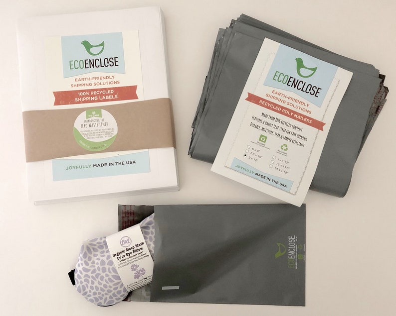 K&ouml;nnte beinhalten: Ein Stapel wei&szlig;er Umschl&auml;ge mit einem braunen Etikett mit der Aufschrift "ECOENCLOSE Umweltfreundliche Versandl&ouml;sungen 100 % recycelte Versandetiketten" und einem gr&uuml;n-wei&szlig;en Aufkleber mit der Aufschrift "Einf&uuml;hrung des Zero Waste Liners" sowie ein Stapel grauer Poly-Versandtaschen mit einem Etikett mit der Aufschrift "ECOENCLOSE Umweltfreundliche Versandl&ouml;sungen Recycelte Poly-Versandtaschen Hergestellt aus 100 % recyceltem Inhalt Mit einem robusten Verschluss f&uuml;r einfaches &Ouml;ffnen Strapazierf&auml;hig, feuchtigkeitsbest&auml;ndig, rei&szlig;fest und manipulationssicher" und eine graue Poly-Versandtasche mit einer lila-wei&szlig;en Augenmaske im Inneren.