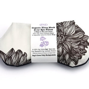 May include: A white organic cotton sleep mask and eye pillow with a black floral print. The mask is made with flaxseed and lavender flowers and has an adjustable latex-free elastic strap. The text on the label reads "Organic Sleep Mask &/or Eye Pillow - 3 Ways to Use (see back) - 100% Org. Cotton Washable Cover" w/Adjustable Latex-free Elastic Strap & 100% Org. Cotton Bag" filled with Org. Flaxseed & Org. Lavender Flowers *GOTS-Cert Fabric & Thread, Low Impact Dyes Bag & Cover Fully Biodegradable"