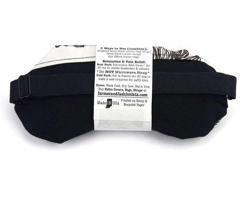 May include: Black sleep mask with a white and brown patterned cover. The mask has an adjustable strap and is made in the USA. The text on the back of the mask reads: "3 Ways to Use (combine): Weighted Sleep Mask (cover-bag-strap) Sleep Mask (cover-strap) Eye Pillow (cover+bag) Relaxation & Pain Relief: Heat Pack: Microwave BAG/Cover for 30 sec to soothe headaches & sinuses *Do NOT Microwave Strap Cold Pack: Put in freezer for 30 min to make a cold compress for puffy eyes Cover: Wash Cold, Dry Low, Warm iron Buy Extra Covers, Bags, Straps at: farmerandfashionista.com Made IN USA Printed on Hemp & Recycled Paper"
