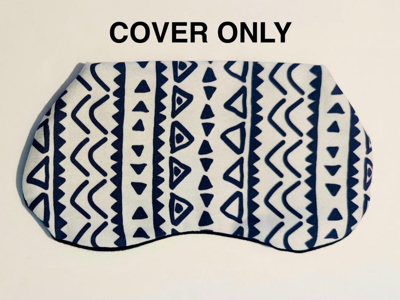 May include: A white sleep mask cover with a navy blue geometric pattern. The pattern includes triangles, chevrons, and zigzags. The mask is outlined in black, and the text "COVER ONLY" is at the top.