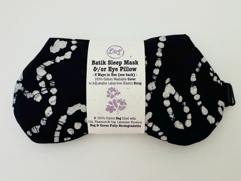 May include: Black batik sleep mask and eye pillow with white abstract patterns. The mask has an adjustable latex-free elastic strap and a 100% cotton washable cover. The product includes a cotton bag filled with organic flaxseed and lavender flowers.