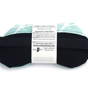 May include: A turquoise and white geometric patterned eye mask with a black adjustable strap. The back of the mask has a white label with instructions for using the mask as a hot or cold compress. The label reads "3 Ways to Use (combine): Welted Mask (cover-bag-strap) Sleep Mask (cover) Eye Pillow (cover-bag) Relaxation & Pain Relief: Heat Pack: Microwave BAG/Cover for 30 sec to soothe headaches & sinuses *Do NOT Microwave Strap Cold Pack: Put in freezer for 30 min to make a cold compress for puffy eyes Cover: Wash Cold, Dry Low, Warm Iron Buy Extra Covers, Bags, Straps at: farmerandfashionista.com Printed on Hemp & Made IN USA Recycled Paper"