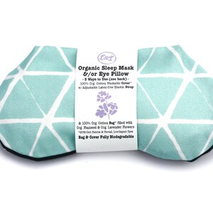 May include: A light blue sleep mask with a white geometric pattern. The mask is made of organic cotton and filled with flaxseed and lavender. The text on the label reads "Organic Sleep Mask &/or Eye Pillow - 3 Ways to Use (see back) - 100% Org. Cotton Washable Cover w/Adjustable Latex free Elastic Strap & 100% Org. Cotton Bag" filled with Org. Flaxseed & Org. Lavender Flowers 005-Cert Fabrics & Thread, Low Impact Dyes Bag & Cover Fully Biodegradable"