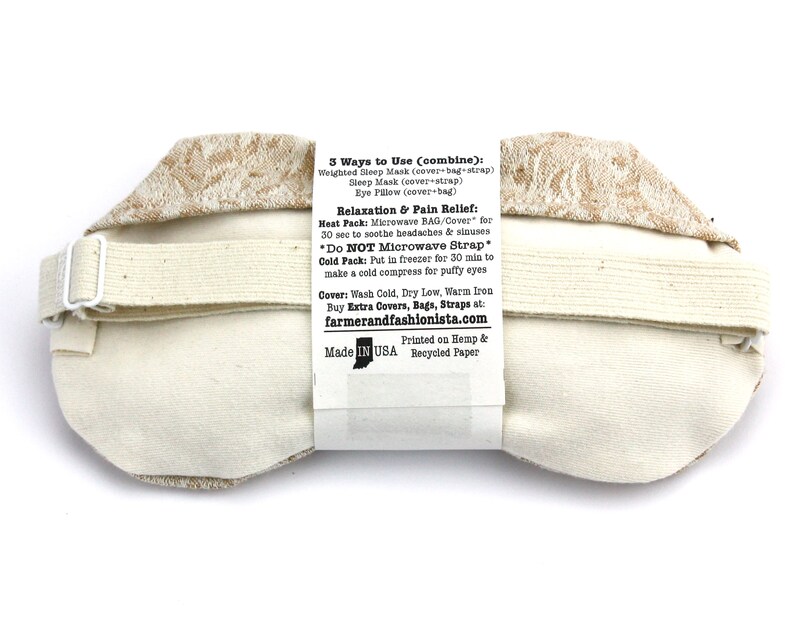 May include: A beige eye mask with a brown floral pattern. The back of the mask has instructions for using it as a heat or cold pack. The text reads: "3 Ways to Use (combine): Weighted Sleep Mask (cover-bag-strap) Sleep Mask (cover+strap) Eye Pillow (cover-bag) Relaxation & Pain Relief: Heat Pack: Microwave BAG/Cover for 30 sec to soothe headaches && sinuses *Do NOT Microwave Strap* Cold Pack: Put in freezer for 30 min to make a cold compress for puffy eyes Cover: Wash Cold, Dry Low, Warm Iron Buy Extra Covers, Bags, Straps at: farmerandfashionista.com Printed on Hemp & Made IN USA Recycled Paper"
