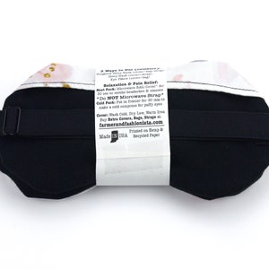 K&ouml;nnte beinhalten: Eine schwarze, gewichtete Schlafmaske mit floralem Muster und verstellbarem Band. Auf der R&uuml;ckseite der Maske befinden sich Anweisungen zur Verwendung, einschlie&szlig;lich der Verwendung als W&auml;rme- oder K&auml;ltekompresse. Der Text auf der R&uuml;ckseite der Maske lautet: "3 Ways to Use (combine 2): Weighted Sleep Mask (cover-strap) Eye Pillow (cover-bag) Relaxation & Pain Relief Heat Pack: Microwave BAG/Cover for 30 sec to soothe headaches & sinuses *Do NOT Microwave Strap* Cold Pack: Put in freezer for 30 min to make a cold compress for puffy eyes Cover: Wash Cold, Dry Low, Warm Iron Buy Extra Covers, Bags, Straps at: farmerandfashionista.com Printed on Hemp & Recycled Paper Made in USA"