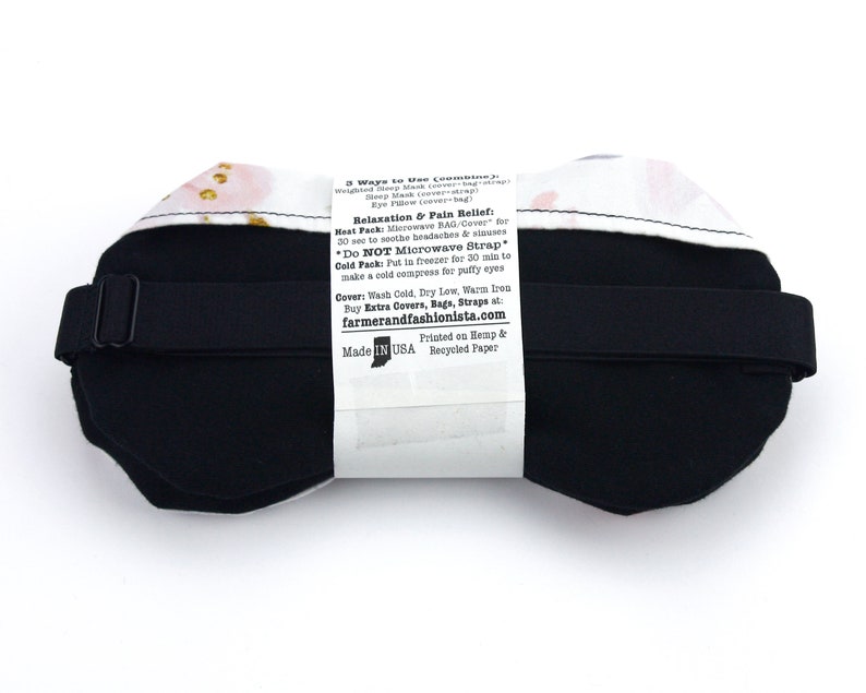 K&ouml;nnte beinhalten: Eine schwarze, gewichtete Schlafmaske mit floralem Muster und verstellbarem Band. Auf der R&uuml;ckseite der Maske befinden sich Anweisungen zur Verwendung, einschlie&szlig;lich der Verwendung als W&auml;rme- oder K&auml;ltekompresse. Der Text auf der R&uuml;ckseite der Maske lautet: "3 Ways to Use (combine 2): Weighted Sleep Mask (cover-strap) Eye Pillow (cover-bag) Relaxation & Pain Relief Heat Pack: Microwave BAG/Cover for 30 sec to soothe headaches & sinuses *Do NOT Microwave Strap* Cold Pack: Put in freezer for 30 min to make a cold compress for puffy eyes Cover: Wash Cold, Dry Low, Warm Iron Buy Extra Covers, Bags, Straps at: farmerandfashionista.com Printed on Hemp & Recycled Paper Made in USA"