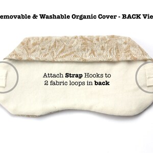 May include: Back view of a white eye mask with a removable and washable organic cover. The cover has a beige floral pattern. The eye mask has two fabric loops on the back for attaching strap hooks.