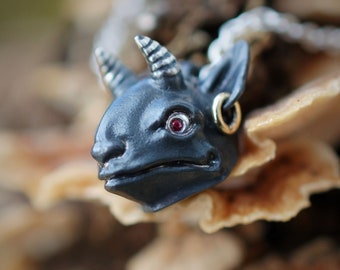 Oxidised sterling silver demon imp pendant with ruby eyes and a solid gold earring, on a strong silver chain. © Adrian Ashley