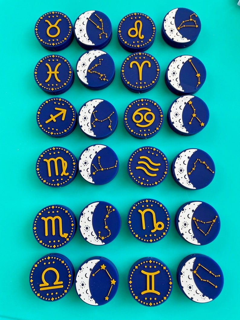 May include: Set of 16 blue and gold zodiac constellation charms with a crescent moon design. Each charm features a different zodiac symbol and constellation.