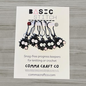 May include: A set of three ceramic mugs with a speckled, matte finish. The mugs are in shades of cream, light gray, and dark gray. Each mug has a simple, minimalist design and a rounded handle.