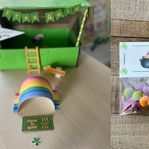 May include: A set of three St. Patrick's Day themed party favors. The first is a green cardboard box with a sign that says "Free Gold" and a rainbow arch. The second is a clear plastic bag with a label that says "Rainbow Seeds" and contains colorful candy. The third is a glass jar with green and white striped straws and a sign that says "Happy St. Patrick's Day!" and "No Pinching".