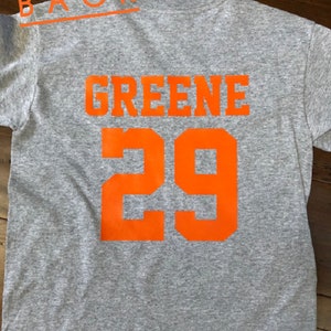 May include: Gray t-shirt with the name "GREENE" and the number "29" printed in orange on the back.