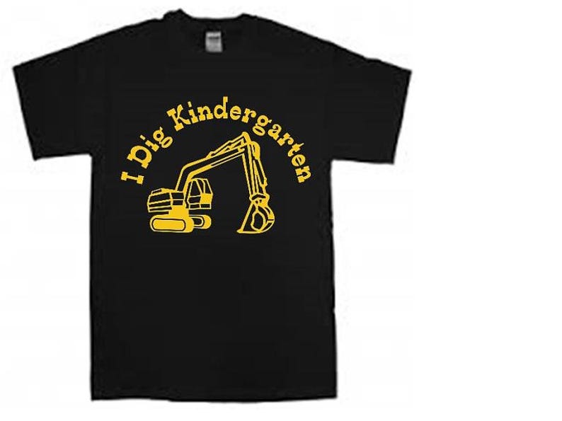 K&ouml;nnte beinhalten: Schwarzes T-Shirt mit einer gelben Baggergrafik und dem Text "I Dig Kindergarten" in einem gelben Kreis.