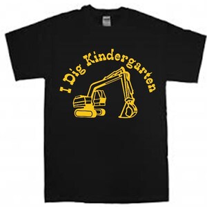 K&ouml;nnte beinhalten: Schwarzes T-Shirt mit einer gelben Grafik eines Baggers und dem Text "I Dig Kindergarten".