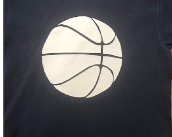 May include: A navy blue t-shirt with a white basketball graphic.