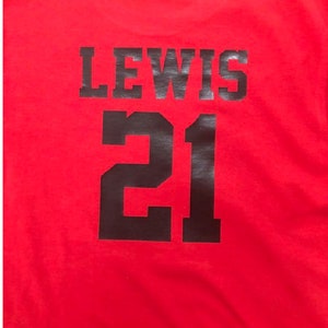 May include: Red t-shirt with black text that says "LEWIS 21" on the back.