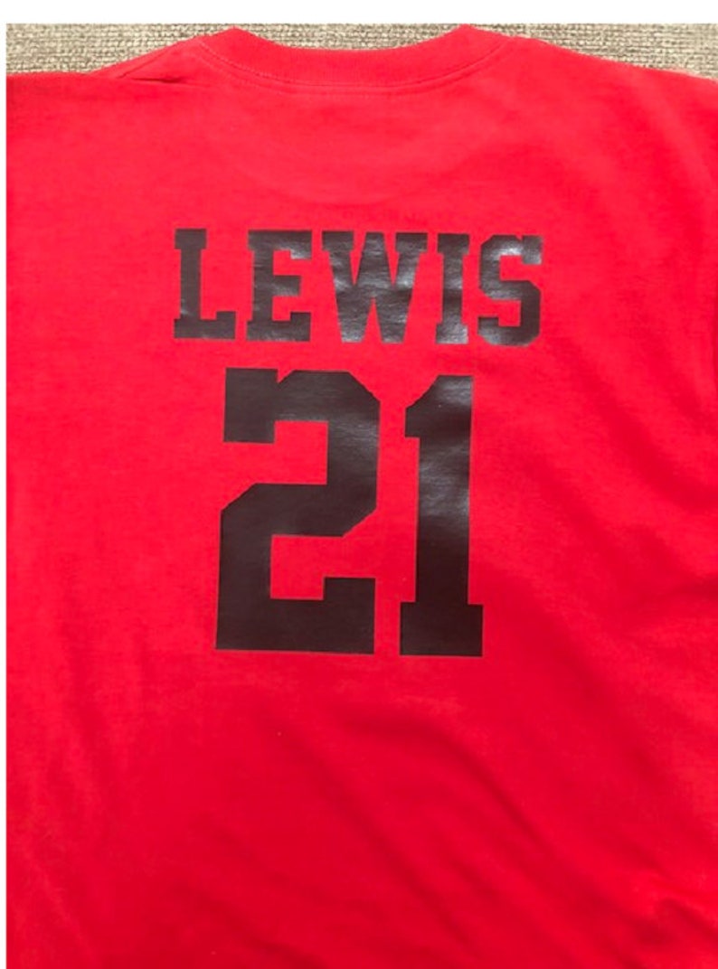 May include: Red t-shirt with black text that says "LEWIS 21" on the back.