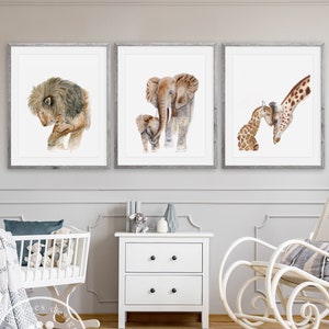 Pode incluir: Tr&ecirc;s impress&otilde;es de animais em aquarela emolduradas com fundo branco. As impress&otilde;es mostram um le&atilde;o, uma elefanta e seu filhote, e uma girafa e seu filhote.