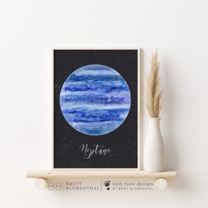以下が含まれることがあります： 黒い背景に白い星が散りばめられた、水彩画で描かれた海王星の絵。惑星は青と白で、渦巻く模様をしています。惑星の真下に「海王星」という文字が白い筆記体で書かれています。