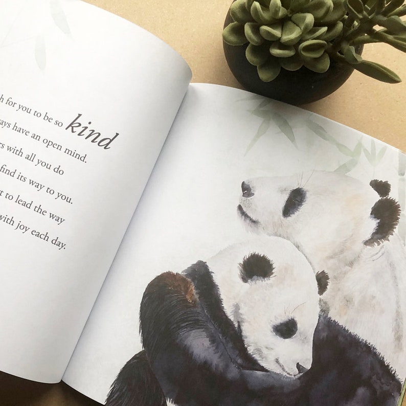 May include: A watercolor illustration of two pandas hugging. The text "kind" is written in cursive on the page.