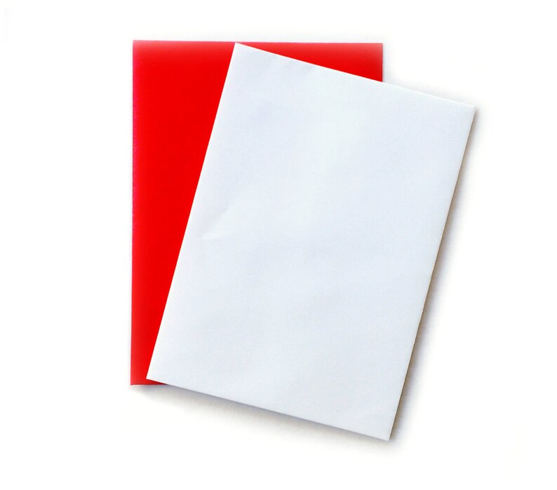 May include: A white sheet of paper is placed on top of a red sheet of paper. Both sheets are rectangular and have a smooth, flat surface.