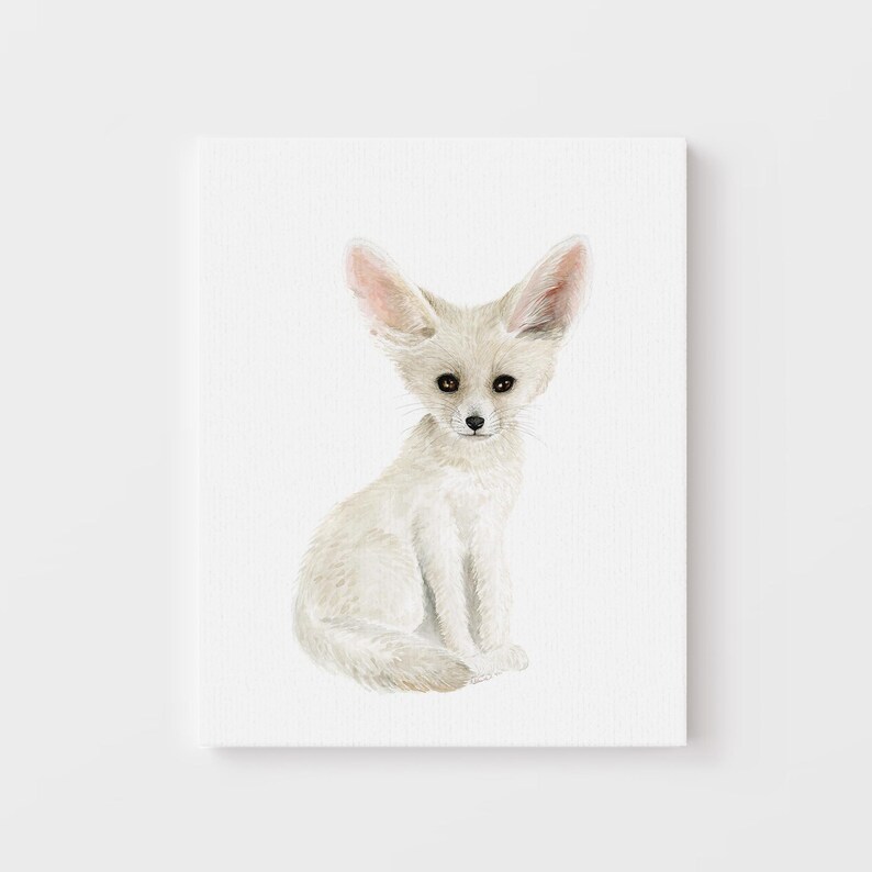 A white fox sitting on its hind legs, looking directly at the camera.