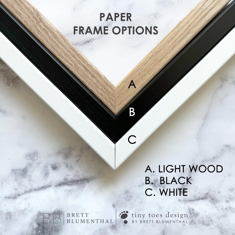 three different frame options for a piece of artwork, each with a different color: light wood, black, and white.