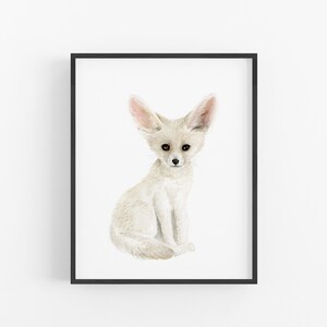 A framed print of a white fox sitting on its hind legs, with its large ears and pointed nose.