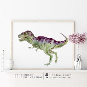 Pode incluir: Pintura em aquarela de um dinossauro verde e roxo em um fundo branco. O dinossauro est&aacute; olhando para a esquerda e tem uma cauda longa. A pintura &eacute; emoldurada em uma moldura de madeira clara.