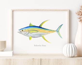 May include: Watercolor print of a Yellowfin Tuna fish. The fish is depicted in shades of blue, yellow, and silver, with detailed fins and scales. The print is framed in a light wood frame and the text "Yellowfin Tuna" is below the fish.