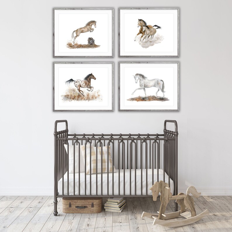 May include: Four framed watercolor paintings of horses running in a field. The paintings are in a white frame with a light wood grain finish. The paintings are hung on a white wall above a dark gray crib.