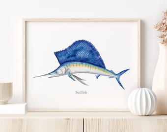 May include: Watercolor print of a sailfish in shades of blue, yellow, and gray, set against a white background. The framed artwork features the word "Sailfish" below the image. The artwork is displayed on a light wood-toned cabinet.