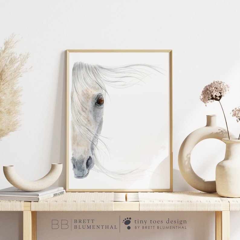 May include: A watercolour painting of a white horse's head with a brown eye, against a white background. The horse's mane is flowing in the wind.