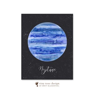 以下が含まれることがあります： 黒い背景に白い星が散りばめられた、水彩画で描かれた海王星のイラスト。惑星は青と白で、渦巻く雲が描かれている。「海王星」という文字が惑星の真下に白い筆記体で書かれている。「tiny toes design by Brett Blumenthal」という文字が惑星の真下に茶色で書かれている。