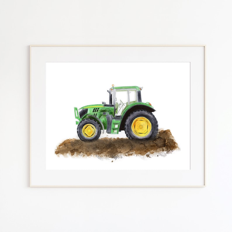 May include: Watercolor painting of a green tractor with yellow wheels. The tractor is depicted on a patch of brown soil, set against a white background. The artwork is framed in a white border.