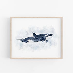 The image is a framed print depicting a watercolor painting of a whale swimming in the ocean.