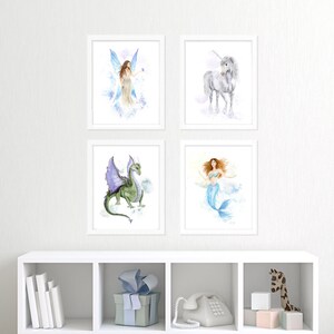 Pu&ograve; includere: Quattro stampe ad acquerello incorniciate con creature fantasy. Le stampe includono una fata, un unicorno, un drago e una sirena. L'opera d'arte &egrave; esposta su una parete bianca sopra una mensola bianca.