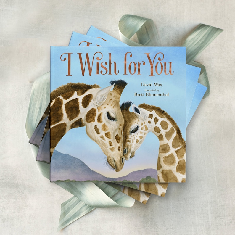 May include: A children's book titled "I Wish for You" with a watercolor illustration of two giraffes nuzzling each other. The book is by David Wax, illustrated by Brett Blumenthal.