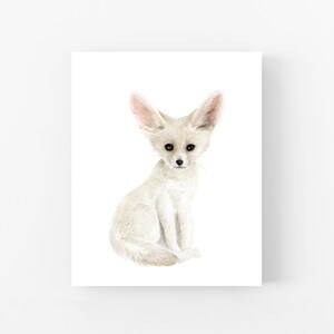 A white fox sitting on its hind legs, looking directly at the camera.