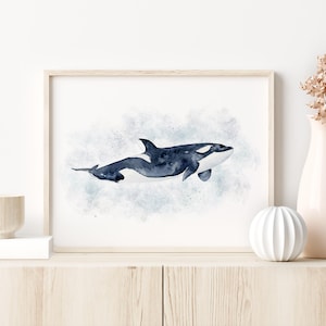 a framed watercolor painting of a whale on a white wall.